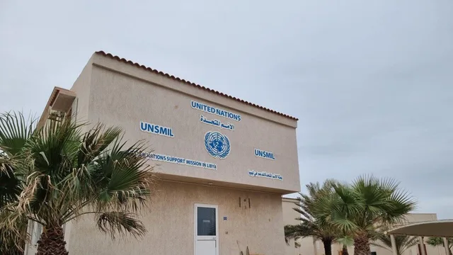 Bâtiment portant l'emblème des Nations unies et le nom de leur mission d'appui en Libye, entouré de palmiers, photo d'archives