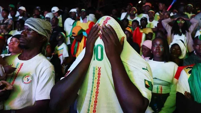 Une foule de supporters sénégalais en maillots de la sélection, l'un se couvrant le visage avec un maillot, photo d'archives