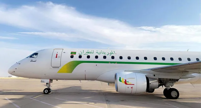 Un avion blanc aux couleurs de Mauritania Airlines sur le tarmac d'un aéroport