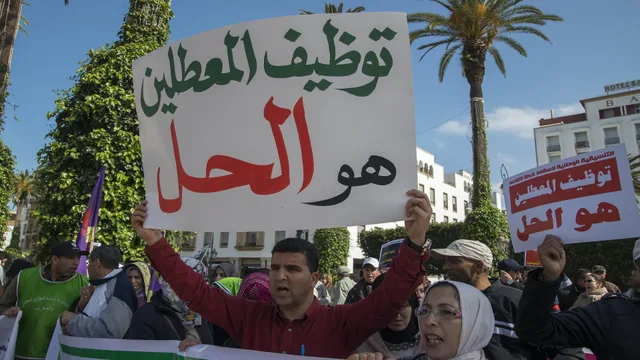 Un manifestant brandit une pancarte appelant à l'emploi des diplômés chômeurs lors d'une manifestation passée sur l'avenue Mohammed V à Rabat, photo d'archives