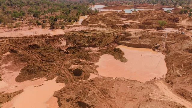 Vue aérienne d'un site d'extraction d'or avec des fosses et des bassins d'eau boueuse sur une terre rouge, photo d'archives