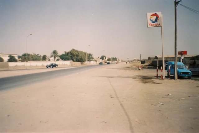 Une large rue de Nouadhibou bordée d'arbres et de bâtiments bas