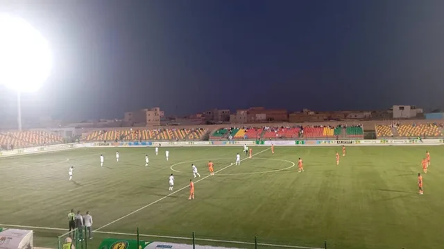 Des joueurs du FC Nouadhibou en orange lors d'un match nocturne dans un stade de Nouakchott