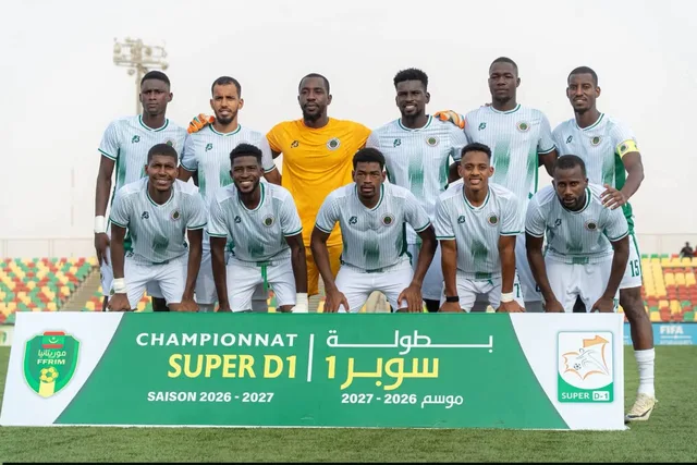 Des joueurs posent pour une photo d'équipe devant une banderole du championnat Super D1