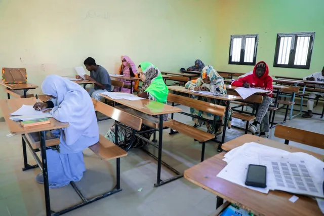 Des élèves assis à des tables dans une salle d'examen, écrivant sur des copies
