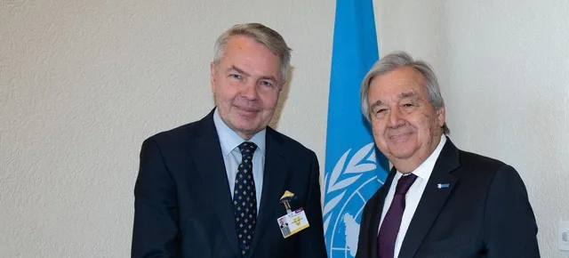 Pekka Haavisto serre la main du secrétaire général de l'ONU António Guterres devant le drapeau des Nations unies, photo d'archives