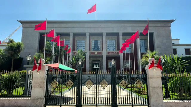 La façade du Parlement marocain à Rabat surmontée de drapeaux marocains