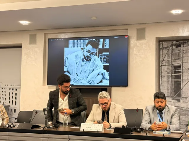 Une photo du défunt universitaire projetée sur un écran lors d'une séance de la conférence à Genève