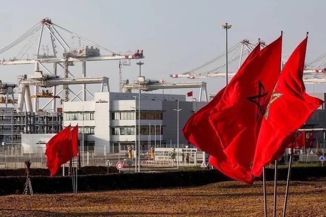 Des drapeaux marocains flottent devant des grues portuaires