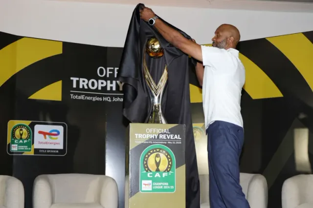 Un homme retire le voile noir du trophée doré de la Ligue des champions CAF lors du dévoilement officiel à Johannesburg, photo d'archives