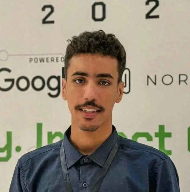 Portrait d'un jeune homme devant un panneau d'événement