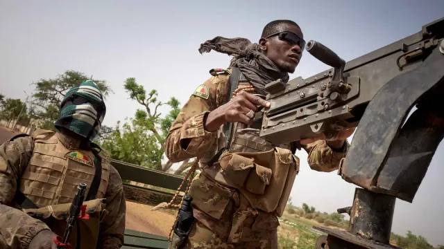 Des soldats maliens à bord d’un véhicule militaire équipé d’une mitrailleuse