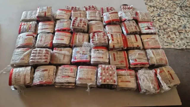 Des paquets de plaquettes de comprimés emballés sous plastique, alignés sur une table après leur saisie, photo d'archives