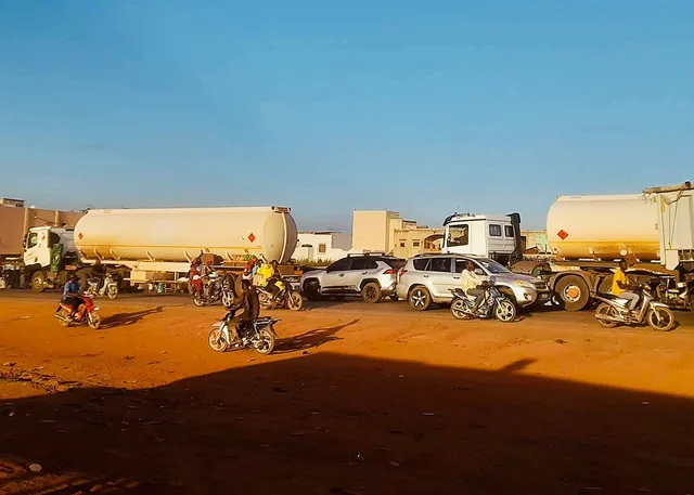 Camions-citernes de carburant, motos et voitures sur une route en terre à Bamako, photo d'archives