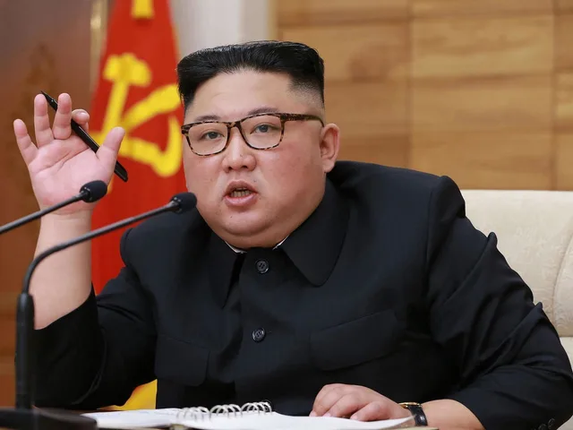 Le dirigeant nord-coréen Kim Jong Un parle derrière deux micros, un stylo à la main, photo d'archives