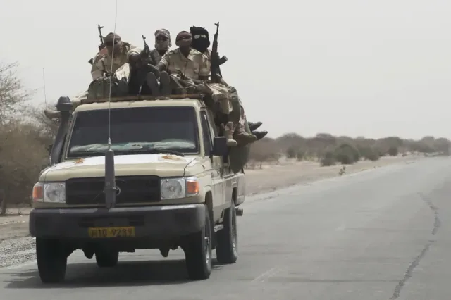 Des militaires armés à bord d'un pick-up sur une route désertique, photo d'archives