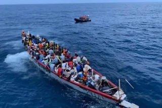 Une pirogue chargée de migrants en mer, près d'un bateau de secours