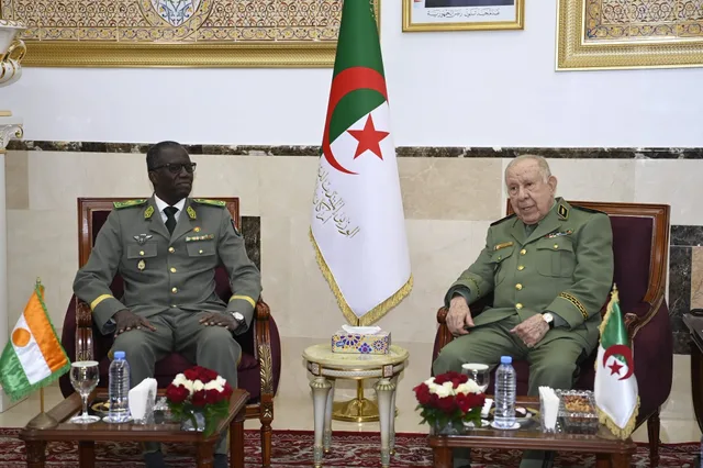 Le chef d'état-major algérien assis aux côtés d'un officier nigérien, devant les drapeaux des deux pays