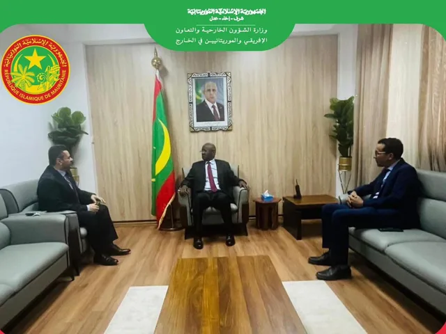 Le ministre mauritanien des Affaires étrangères reçoit des visiteurs à son bureau, drapeau mauritanien derrière lui
