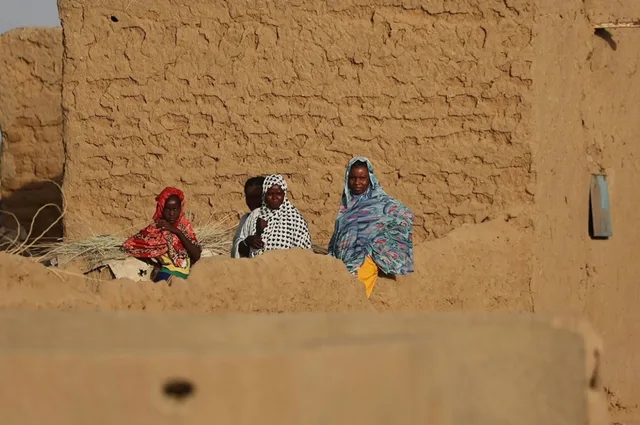 Des femmes et des enfants devant un mur en banco dans une localité du nord du Mali