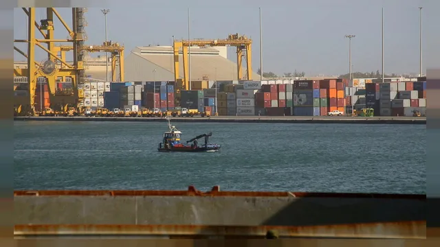 Conteneurs et portiques sur un quai du port de Dakar, un petit bateau sur l'eau