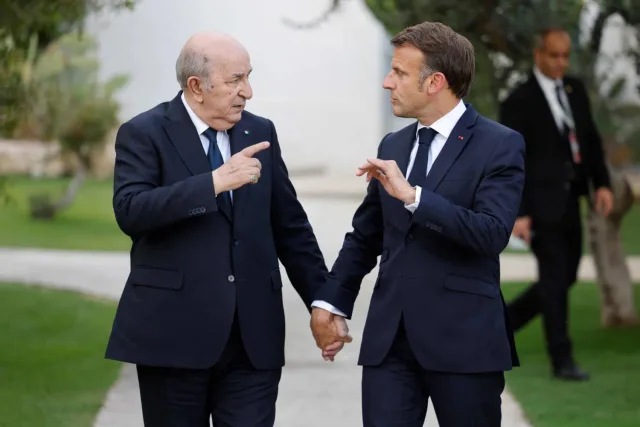 Abdelmadjid Tebboune et Emmanuel Macron marchant côte à côte dans un jardin