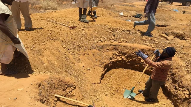 Des chercheurs d'or creusent dans le sable du désert