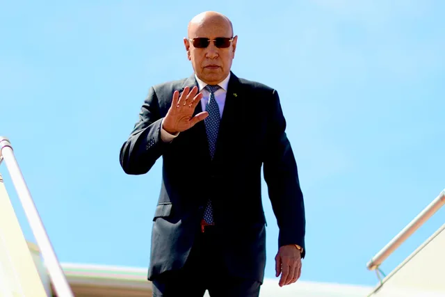 Le président Mohamed Ould Cheikh El Ghazouani salue de la main en haut de la passerelle d'un avion
