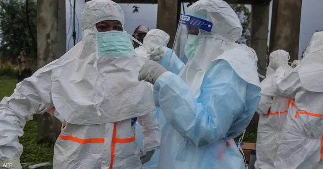 Des agents de santé en combinaisons de protection et visières