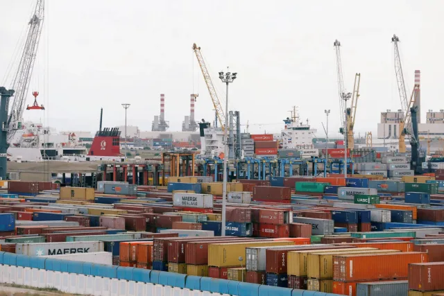 Des rangées de conteneurs colorés, des grues et des navires dans un port de commerce, photo d'archives