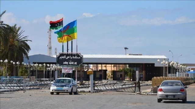 L'entrée du poste frontalier de Ras Jedir côté libyen, avec le drapeau libyen et deux voitures devant le portail, photo d'archives