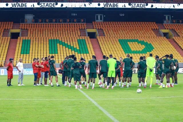 Les tribunes jaunes et vertes du stade Abdoulaye Wade de Diamniadio et des joueurs réunis sur la pelouse à l'entraînement, photo d'archives