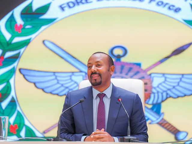 Le Premier ministre éthiopien Abiy Ahmed assis derrière des micros devant l'emblème des forces de défense, photo d'archives