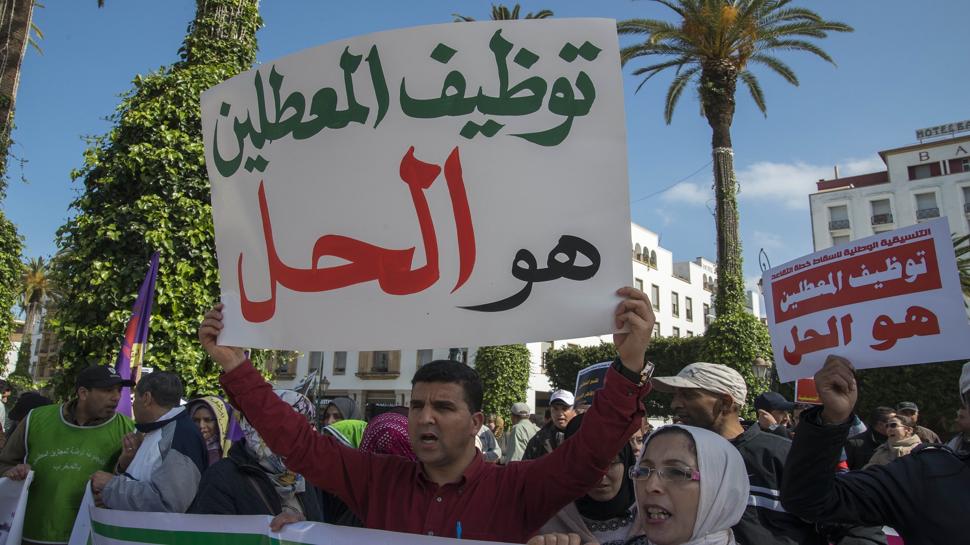 Un manifestant brandit une pancarte appelant à l'emploi des diplômés chômeurs lors d'une manifestation passée sur l'avenue Mohammed V à Rabat, photo d'archives