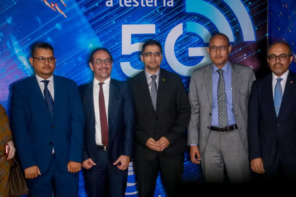 Des responsables posent devant une banderole d'un test de réseau 5G