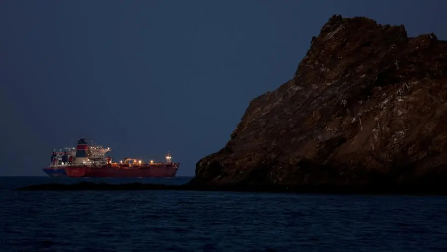 Un pétrolier naviguant près d'une côte rocheuse au crépuscule, photo d'archives