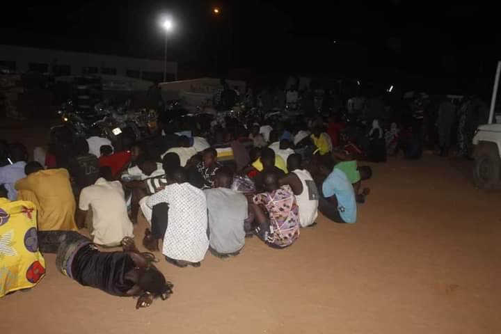 Des personnes assises au sol la nuit dans une cour lors d'une opération de police au Niger, photo d'archives
