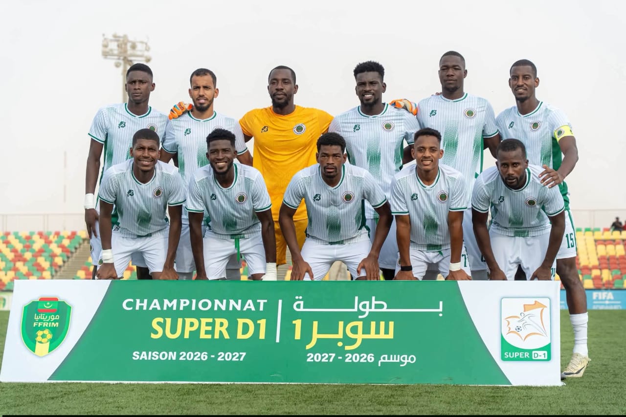 Des joueurs posent pour une photo d'équipe devant une banderole du championnat Super D1