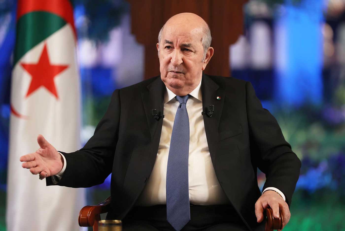 Le président algérien Abdelmadjid Tebboune, assis devant le drapeau algérien