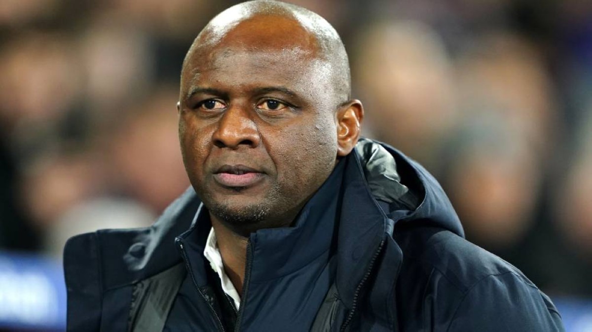 Patrick Vieira en veste sombre au bord d'un terrain de football