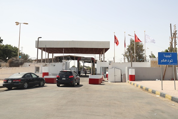 L'entrée d'un poste-frontière terrestre entre la Tunisie et la Libye, avec des voitures et un panneau « La Libye vous dit au revoir », photo d'archives