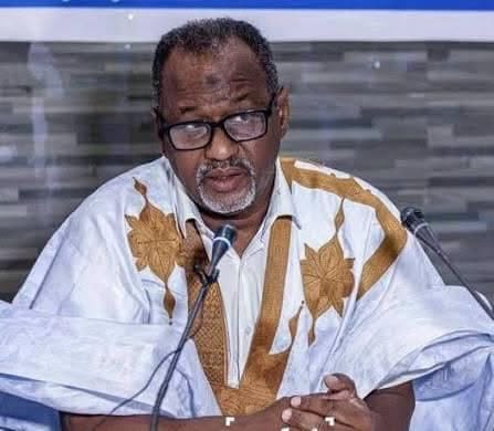 Un responsable syndical en boubou blanc s'exprime devant des micros