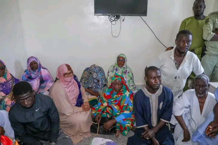 Des membres de la famille et des responsables assis dans une pièce lors de la visite de condoléances