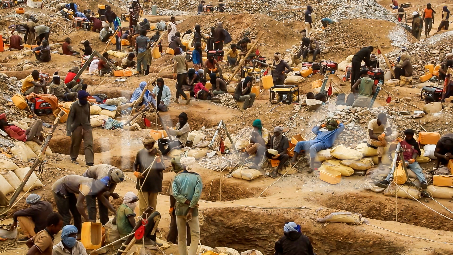 Des dizaines d'orpailleurs travaillant entre fosses et sacs sur un site d'orpaillage, image d'illustration d'archives