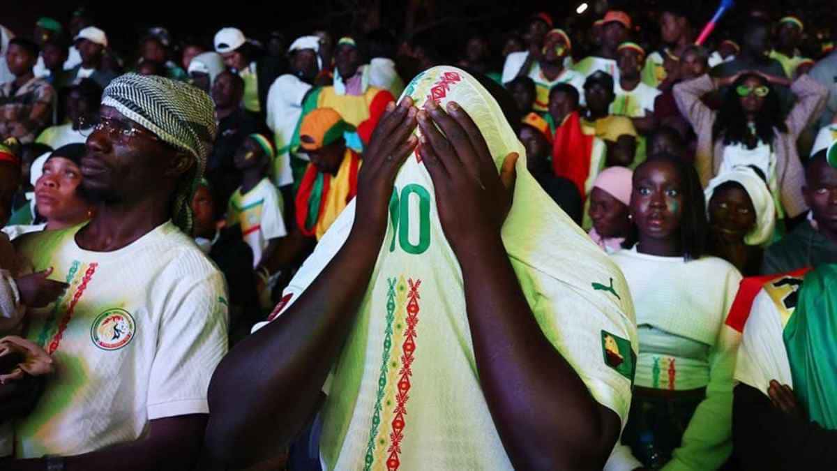 Une foule de supporters sénégalais en maillots de la sélection, l'un se couvrant le visage avec un maillot, photo d'archives
