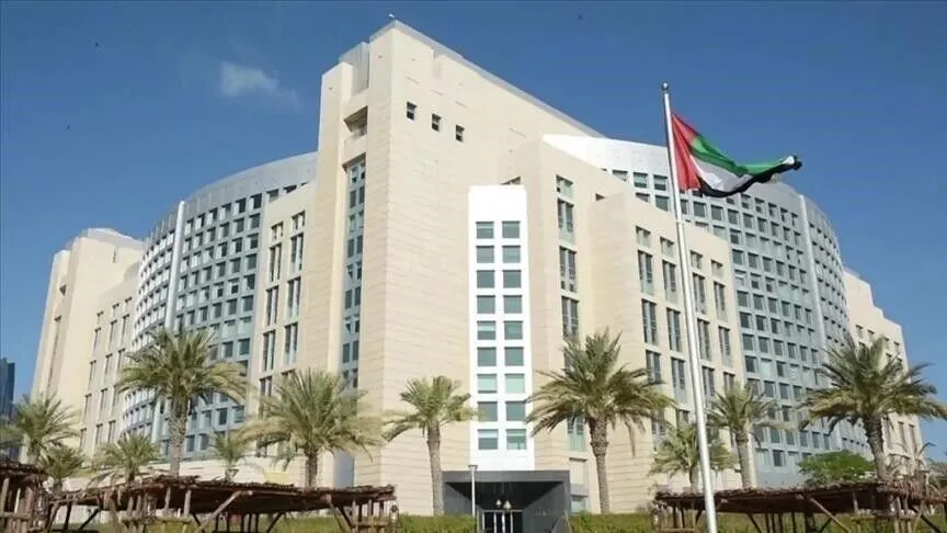 Un grand bâtiment gouvernemental devant lequel flotte le drapeau émirati, entouré de palmiers, à Abou Dhabi, photo d'archives