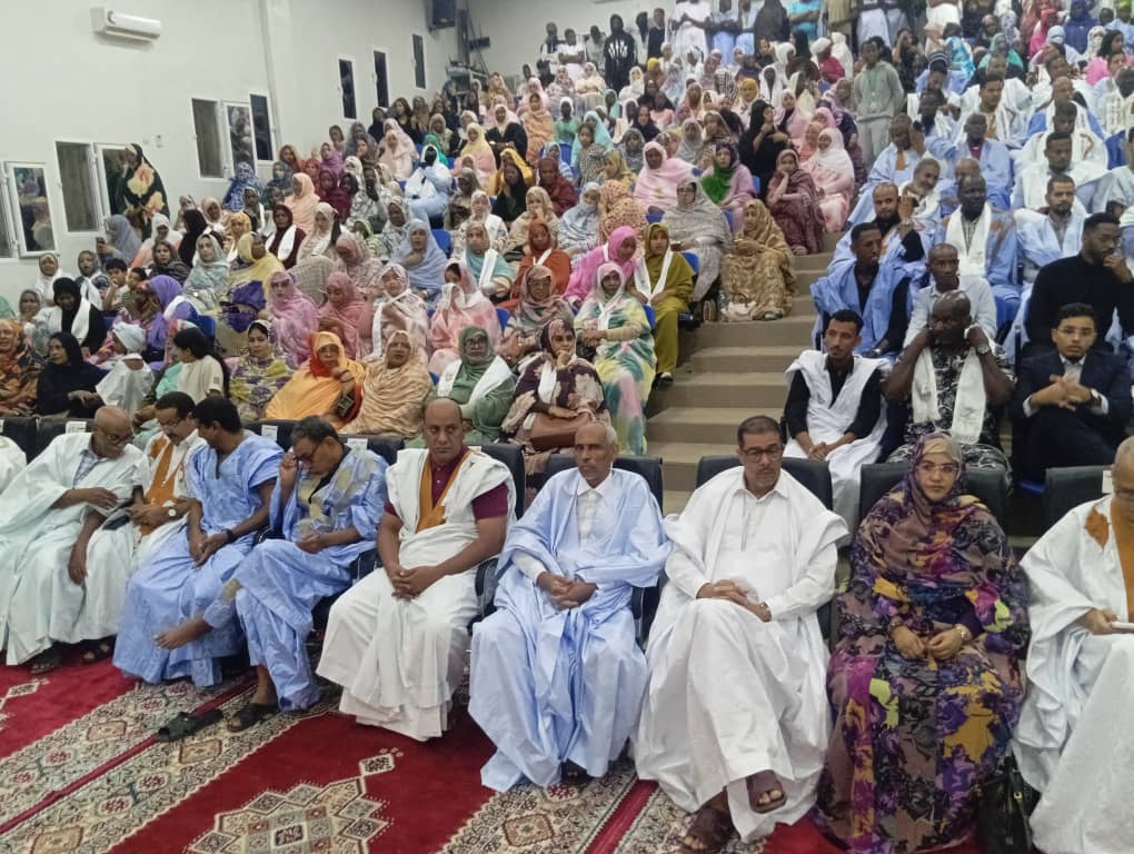 Un public d'hommes et de femmes dans une salle lors d'une activité culturelle