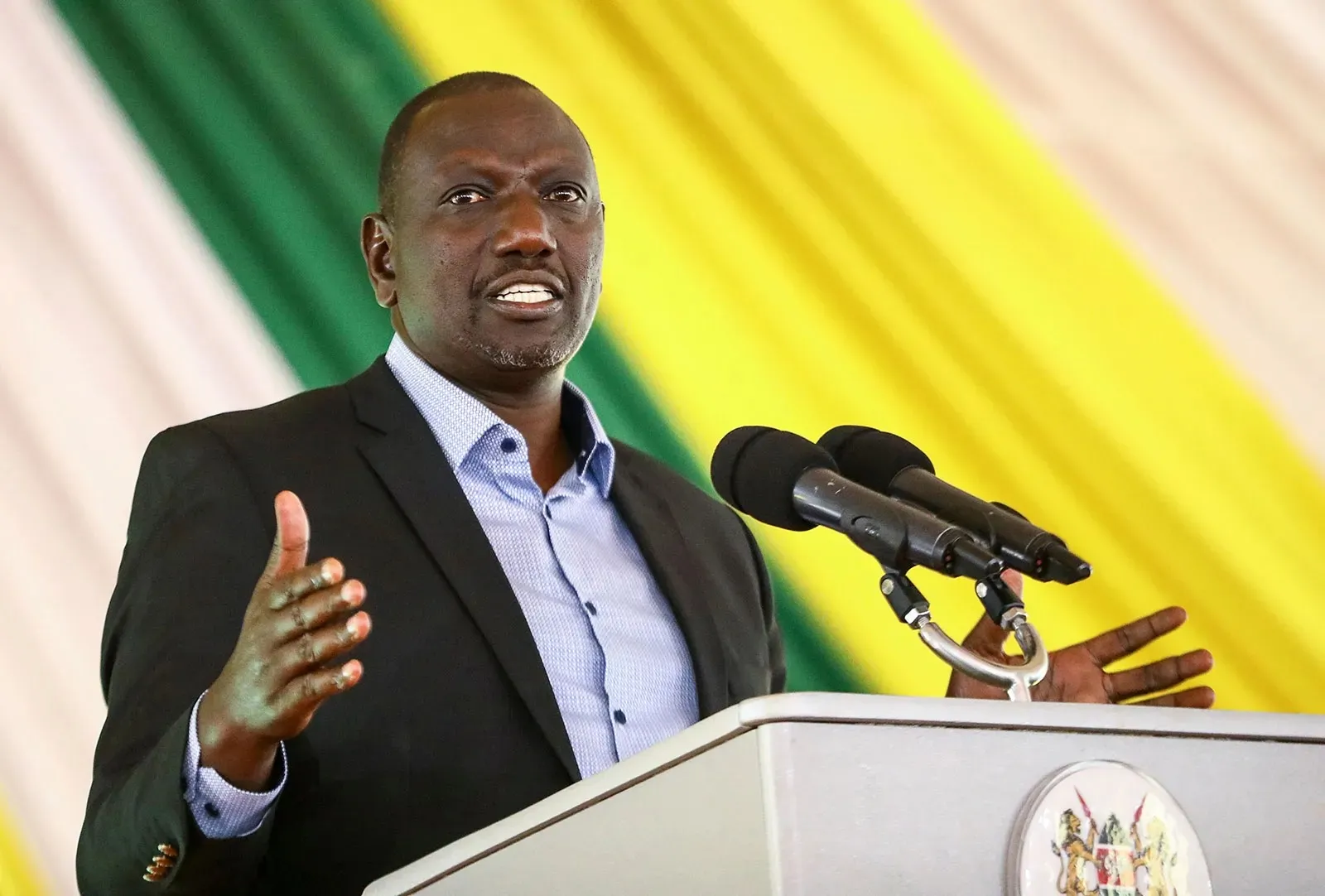 Le président kényan William Ruto s'exprimant derrière un pupitre devant un fond aux couleurs du drapeau kényan, photo d'archives