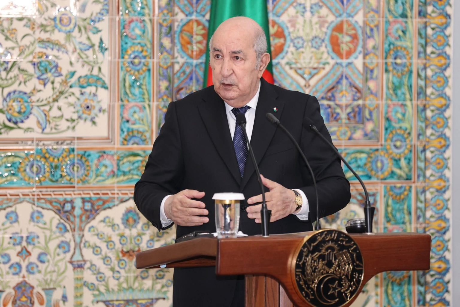 Le président algérien Abdelmadjid Tebboune s'exprimant derrière un pupitre devant un mur de faïence, photo d'archives
