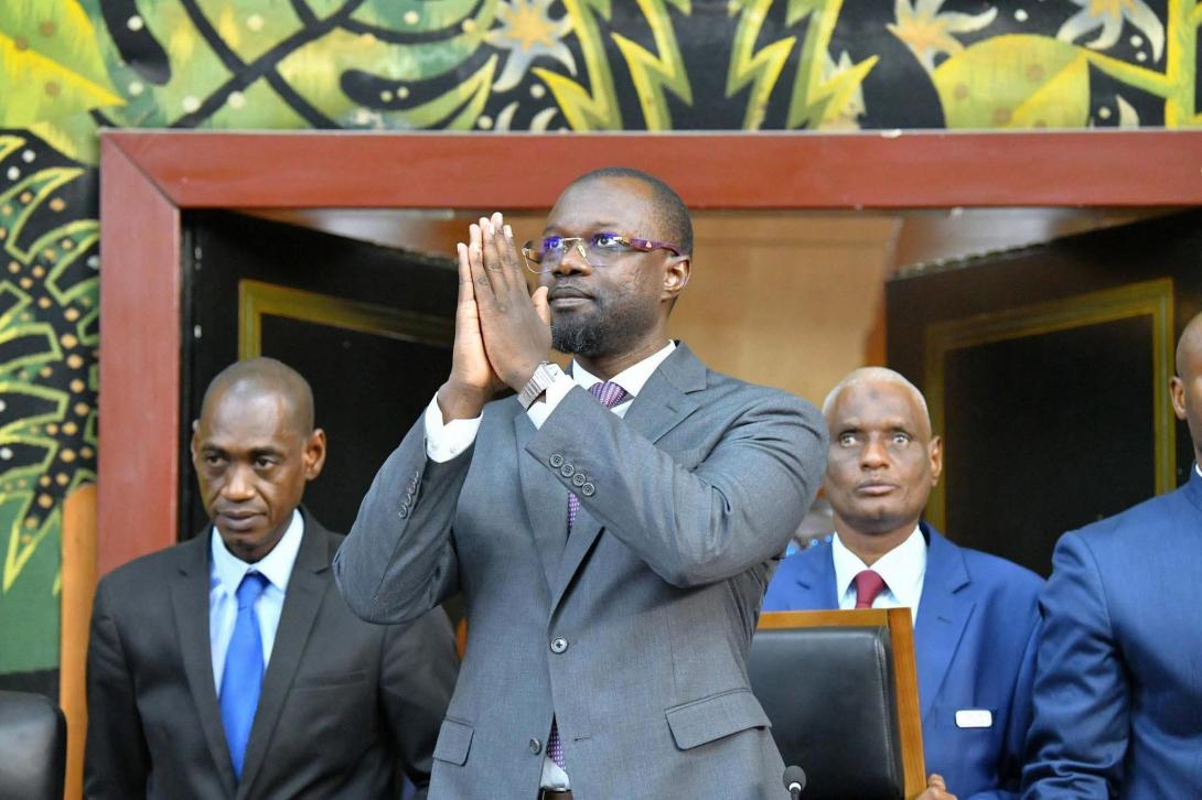 Ousmane Sonko, mains jointes, salue dans l'hémicycle de l'Assemblée nationale sénégalaise
